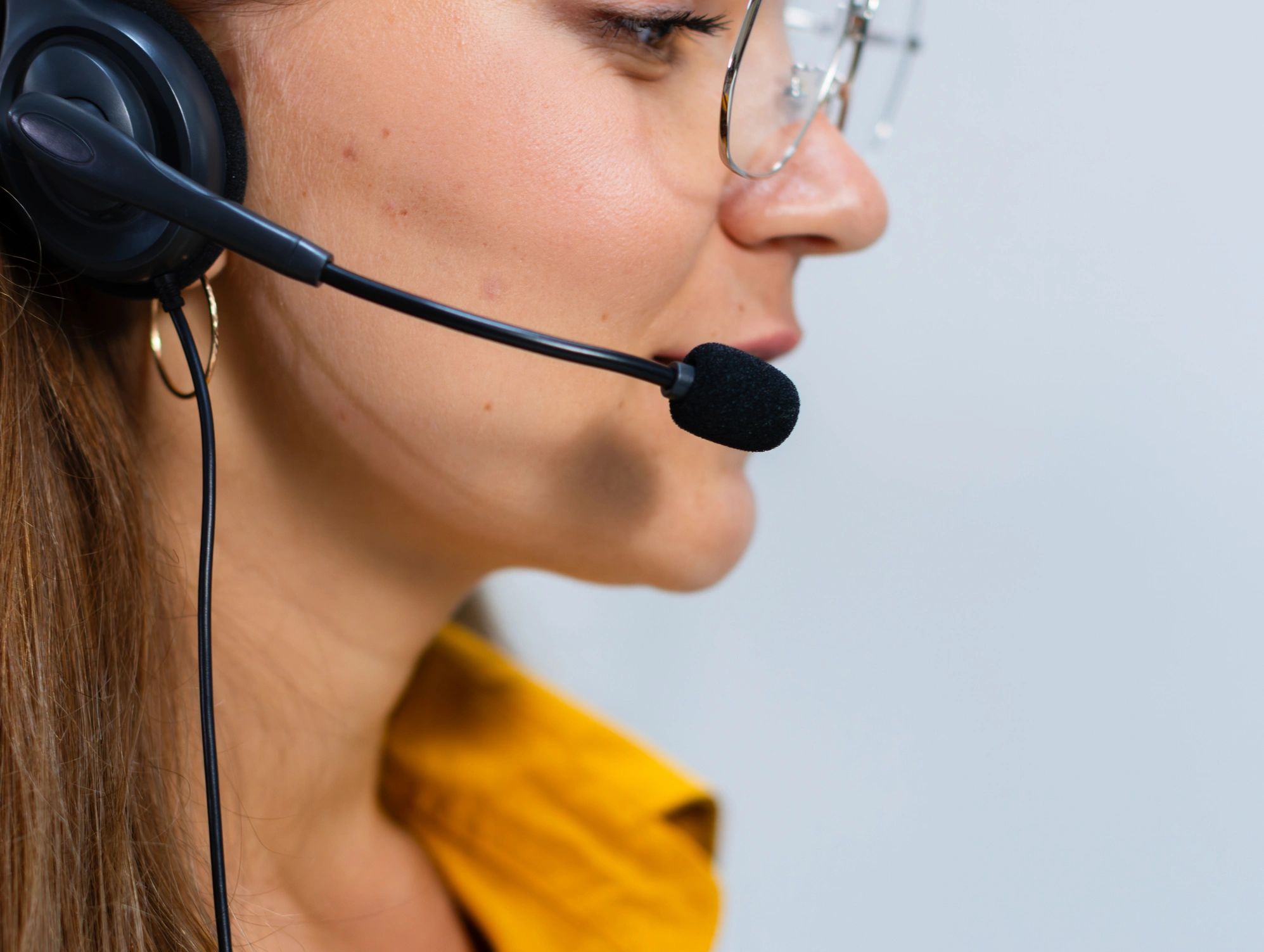 Customer support specialist wearing a headset at a computer